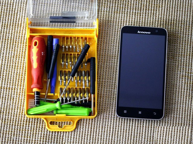 拆机前的准备工作,依然是手机事业部常用的拆机工具箱。其中包含多种不同类型的改锥头,撬棒,以及几个常用的螺丝刀,还有更利于进行细节工作的镊子。当然右边即为等待被拆卸并查看内在的联想手机A8,整体看去相当的简洁大方。