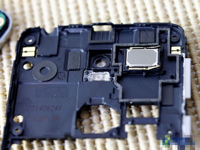 中框内层的设计部分,右侧长方形面积是扬声器单元,这与一般手机将扬声器设计在手机下方有所不同。如果你看上一张图的话,会发现主板相应部分有一处同等大小的空缺,这就是中框扬声器卡扣在主板上的部位。除了扬声器单元,闪光灯灯罩也可看到。